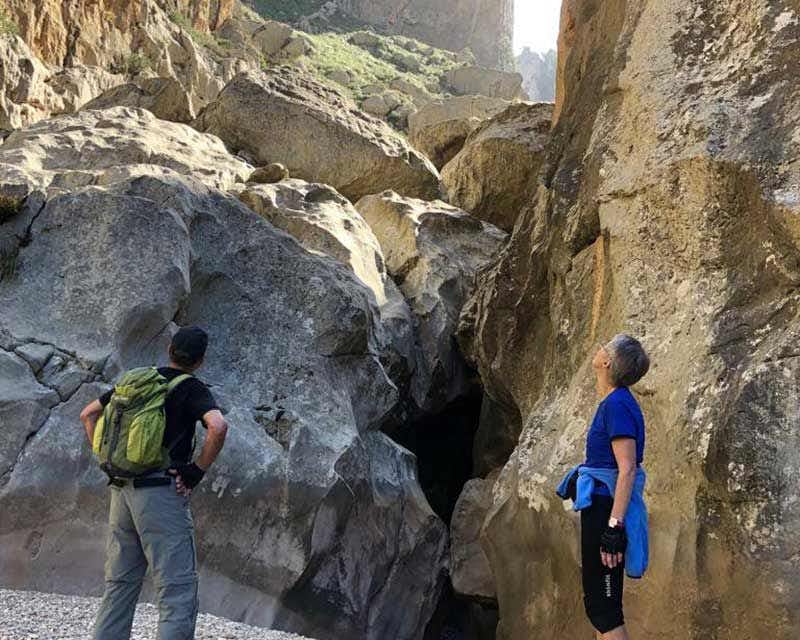 dos personas admirando el tamano de las rocas del torrent