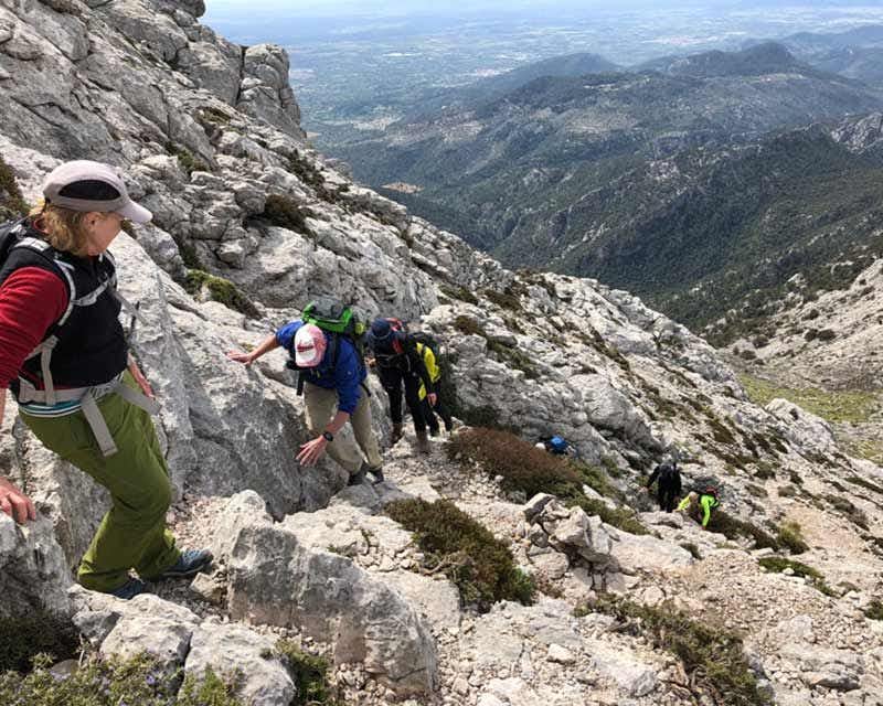 excursionistas subiendo el sendero gr221 alpino