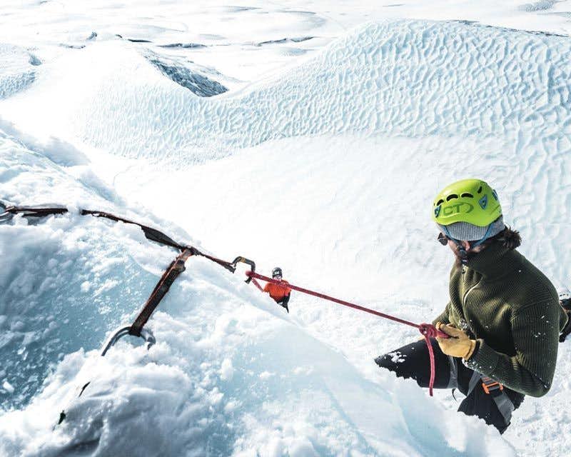 aventurero haciendo  rappel en el glaciar skaftafell 