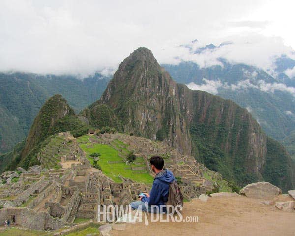 Viajero sentado en una cornisa contempla la totalidad del Valle Sagrado
