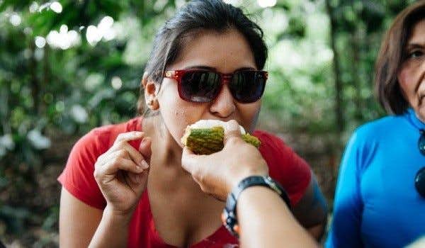chica probando frutas tropicales en la Chacra