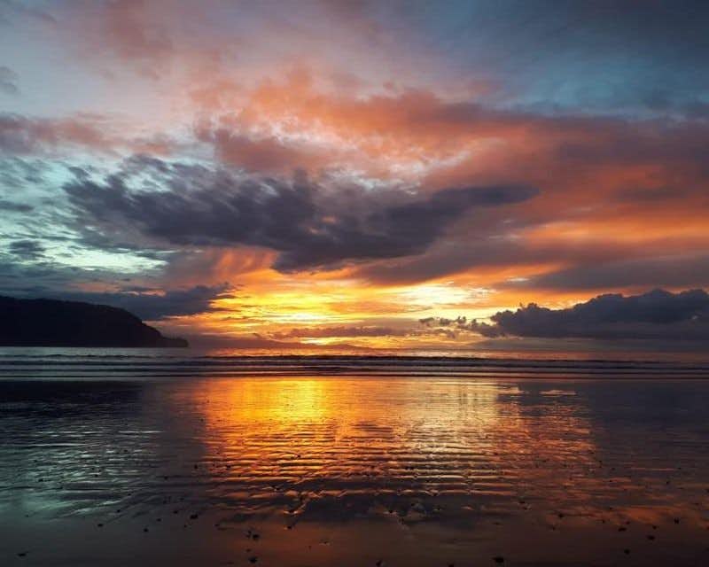Ciel orange au coucher du soleil dans les eaux calmes de la baie de Paquera