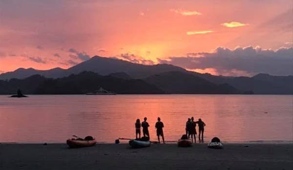Voyageurs avec leurs kayaks lors d'un coucher de soleil et d'une excursion nocturne dans la baie de Paquera.