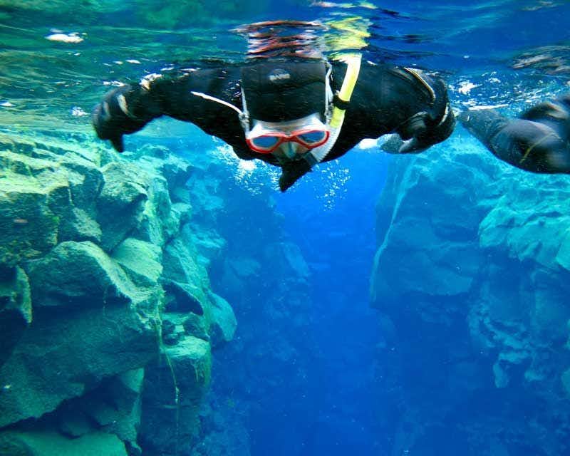 un garçon faisant du snorkeling dans les profondeurs de la faille de silfra