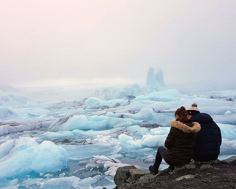 couple assis sur un rocher dans le jokulsarlon glacier