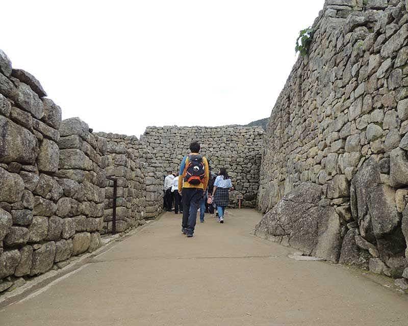 garçon howlanders se promenant dans les ruines de Machu Picchu