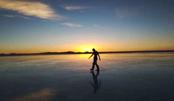 Turista al tramonto sul Salar de Uyuni Howlanders