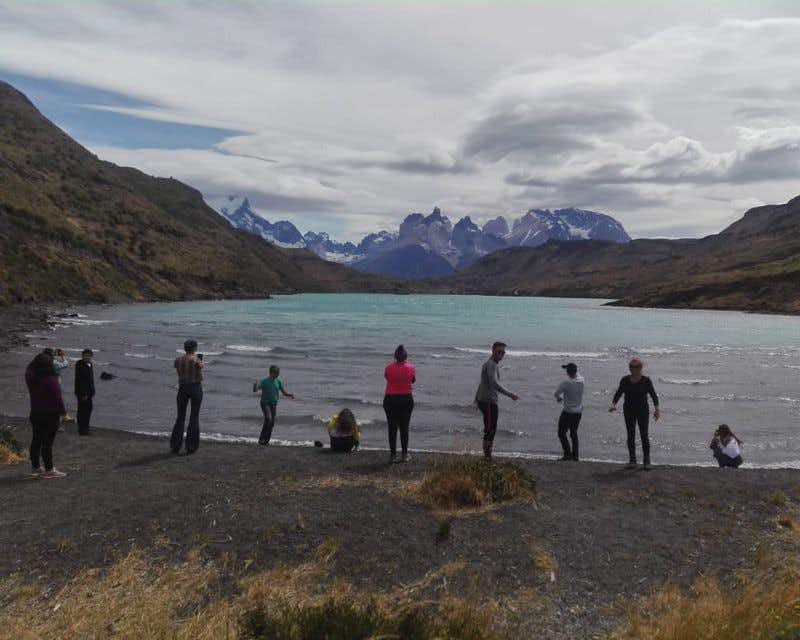 Viaggiatori sulla spiaggia del lago a Torres del Paine