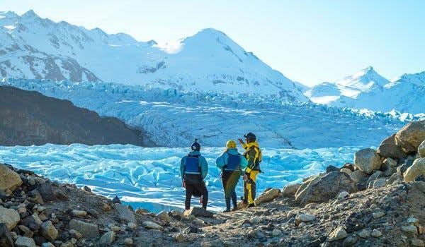 tre persone sulla morena del ghiacciaio grigio