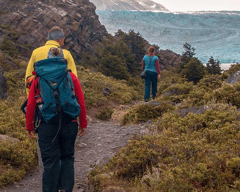 viaggiatori che camminano verso il ghiacciaio grigio