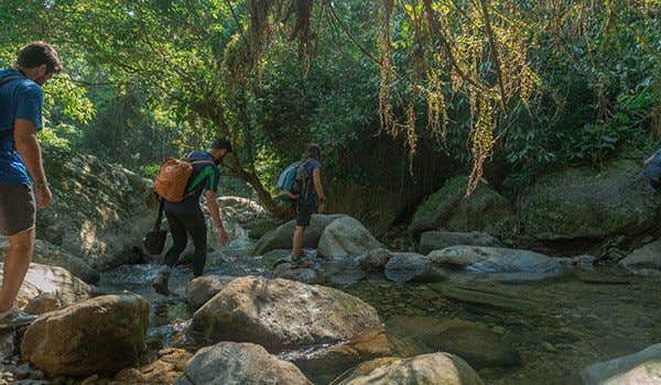 escursionisti che attraversano un fiume in una città perduta