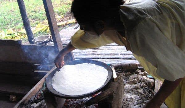 Donna che cucina la manioca