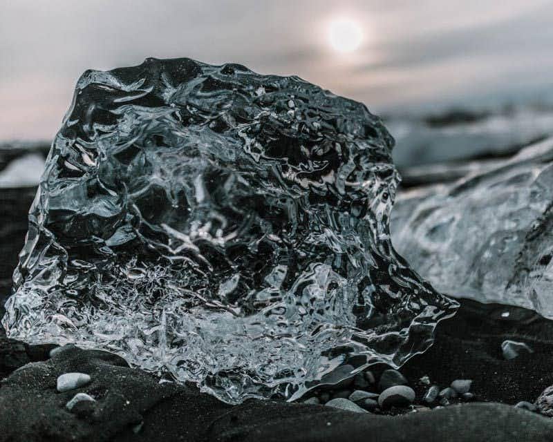 Blocco di ghiaccio su sabbia nera a Jökulsárlón
