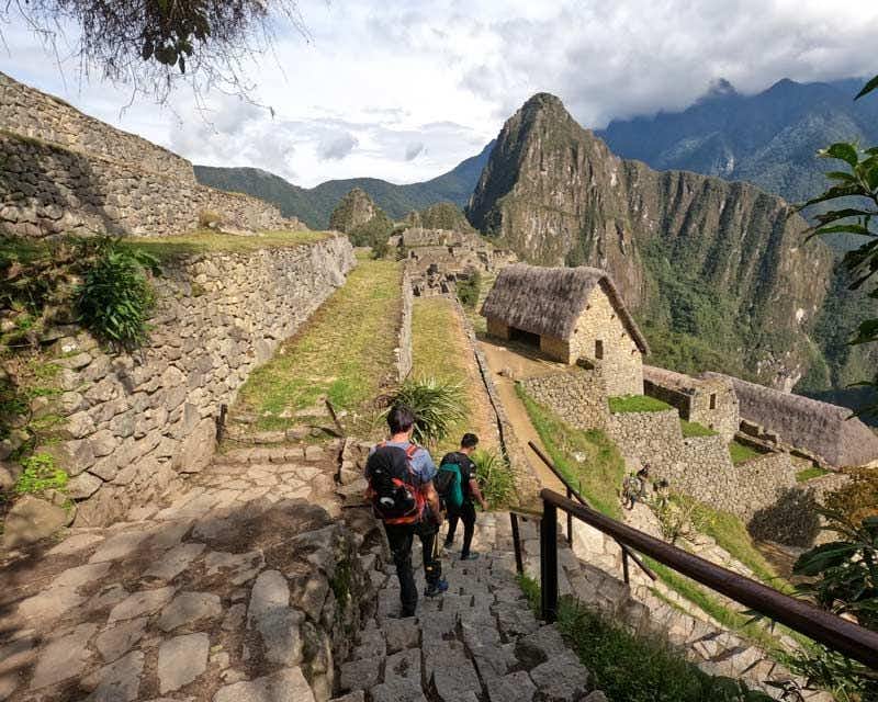 Gruppo che scende le scale durante la visita guidata di Machu Picchu 