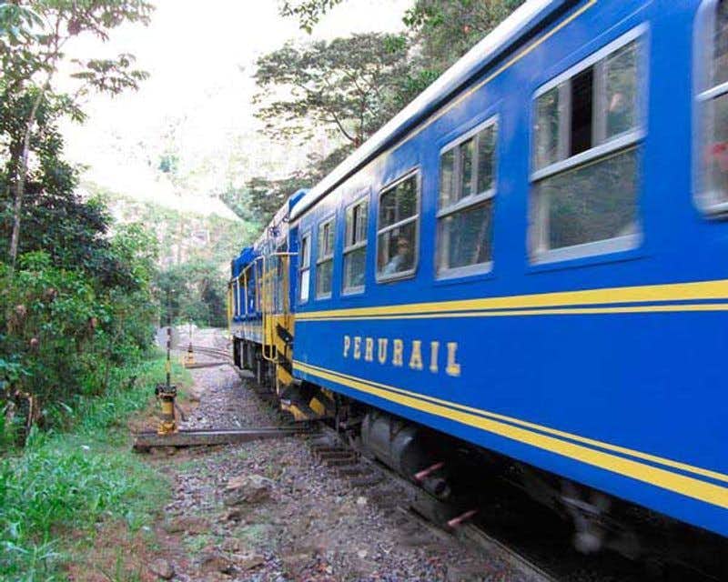 Vista laterale del treno blu Peru Rail Expedition che trasporta i viaggiatori da Aguas Calientes a Machu Picchu.