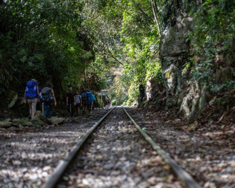 persone che camminano lungo i binari del treno durante il trekking nella giungla Inca
