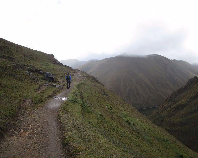 escursionista in spalla che cammina su un sentiero delle Ande