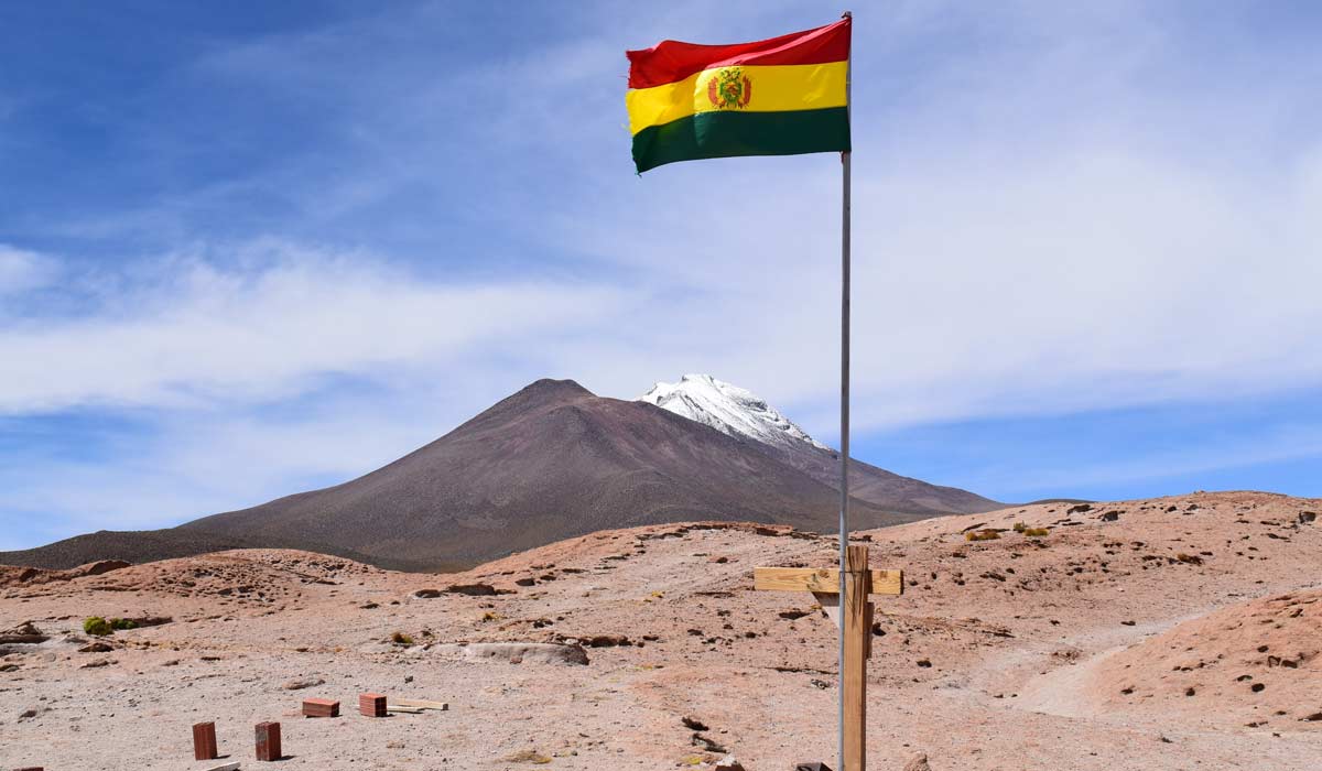 bandera de bolivia frente a un volcán