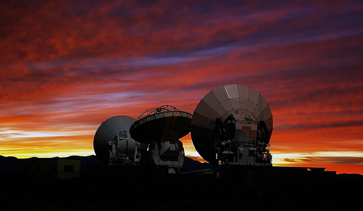 alma observatory telescopes with sunset in the background