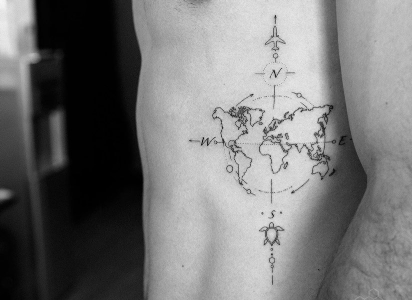 globe travel tattoo on a boy abdomen in black and white