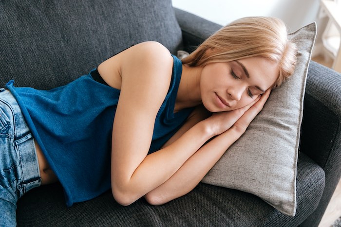 Chica rubia durmiendo en un sofá