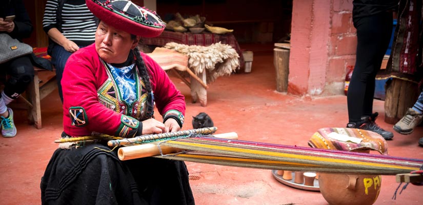 woman in peruvian market weaving traditional clothes