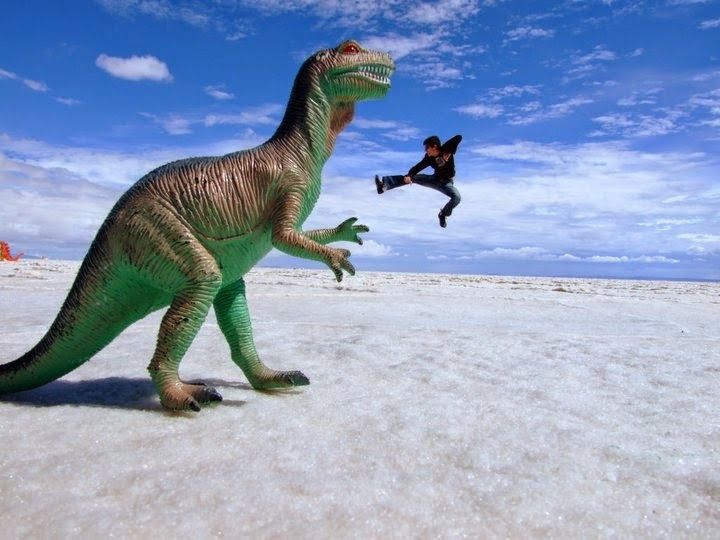 man playing with perspective on a toy dinoasaurus in Uyuni Salt Flats