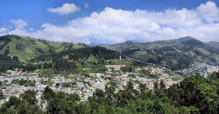La ciudad de Quito vista desde lejos entre volcanes