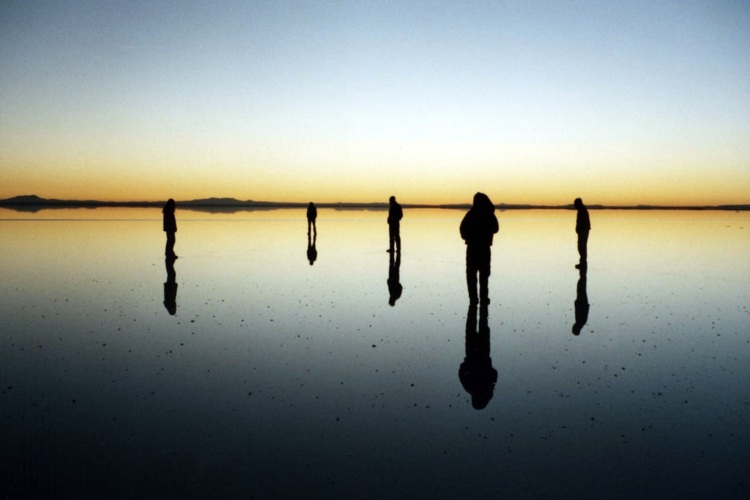 shadows of tourists created by the sunset in the uyuni salt flats