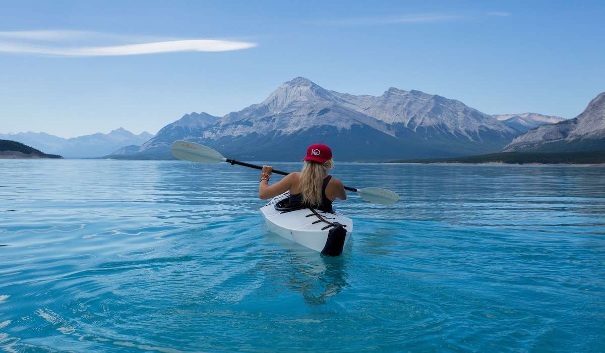 Mujer haciendo kayak en un lago