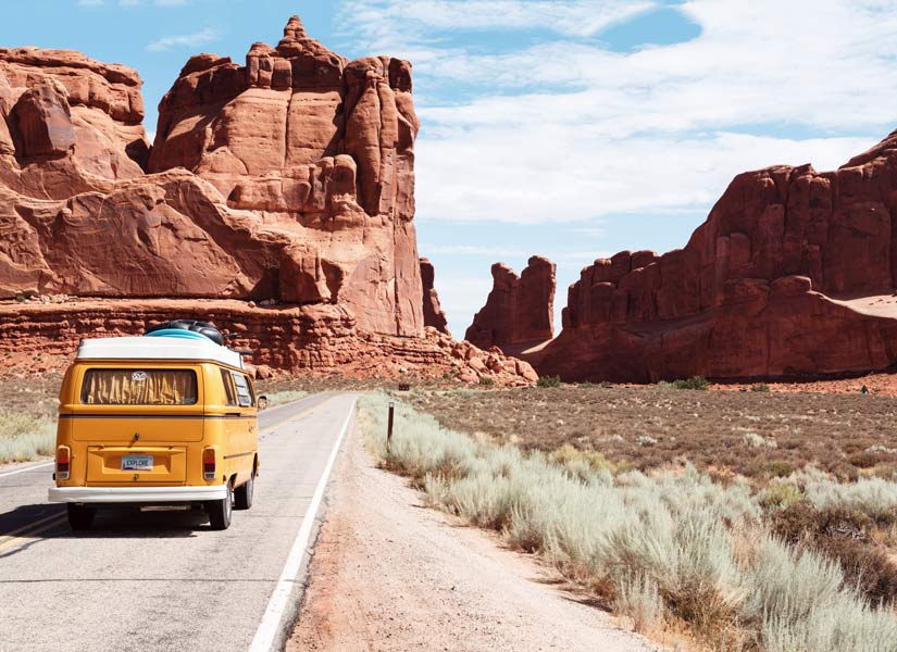 furgoneta amarilla en carretera por desierto en road trip