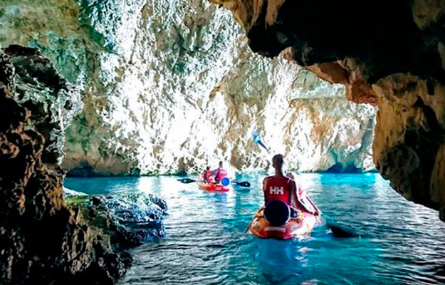 Persona en kayak por cueva marina Jávea